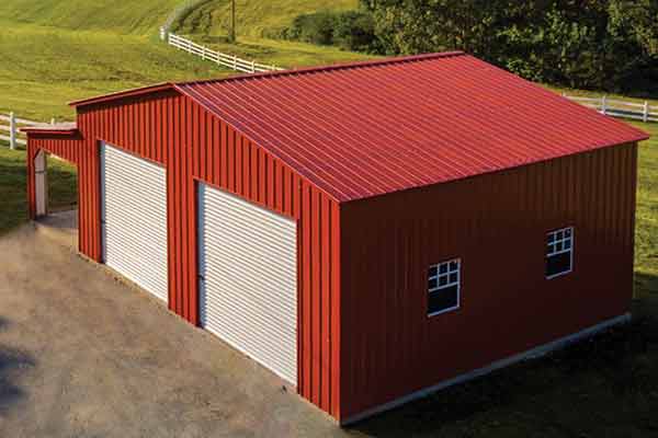 Large red enclosed barn with open lean to section on one side.