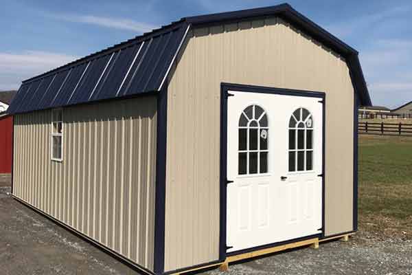 Dutch barn style metal shed in tan with navy trim