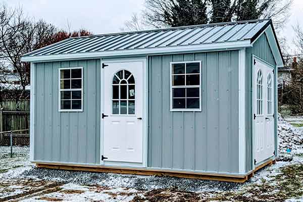 Small light blue metal shed in the snow